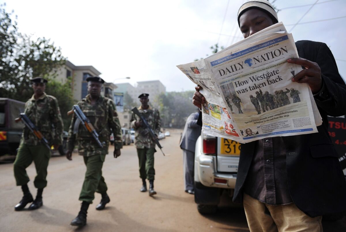 A man reads Wednesday's paper in Nairobi after Kenyan forces took back control of Westgate mall following a days-long siege that killed scores of people.