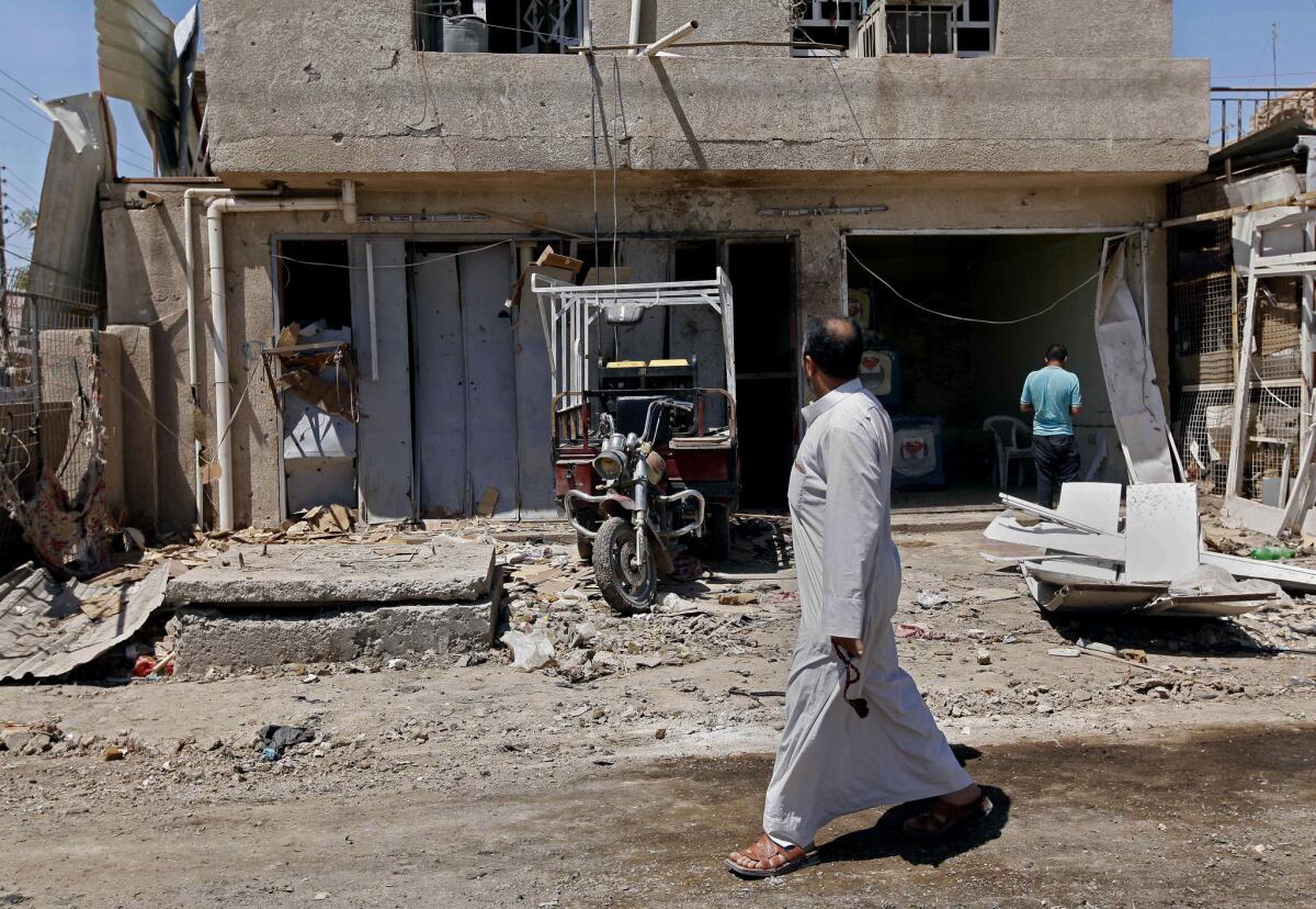 Civilians inspect the aftermath of a car bomb attack in the Husseiniyah area of northeastern Baghdad.