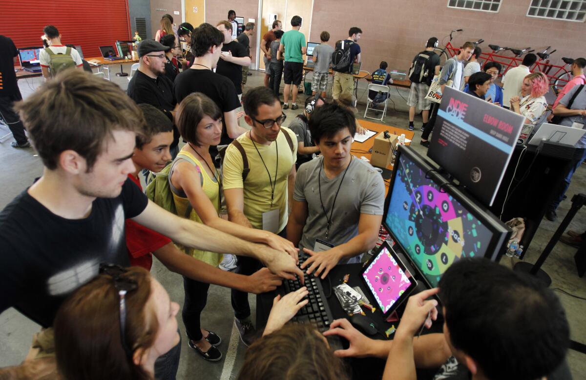 A group plays the game "Elbow Room" during IndieCade 2014 in Culver City on Oct. 11, 2104.