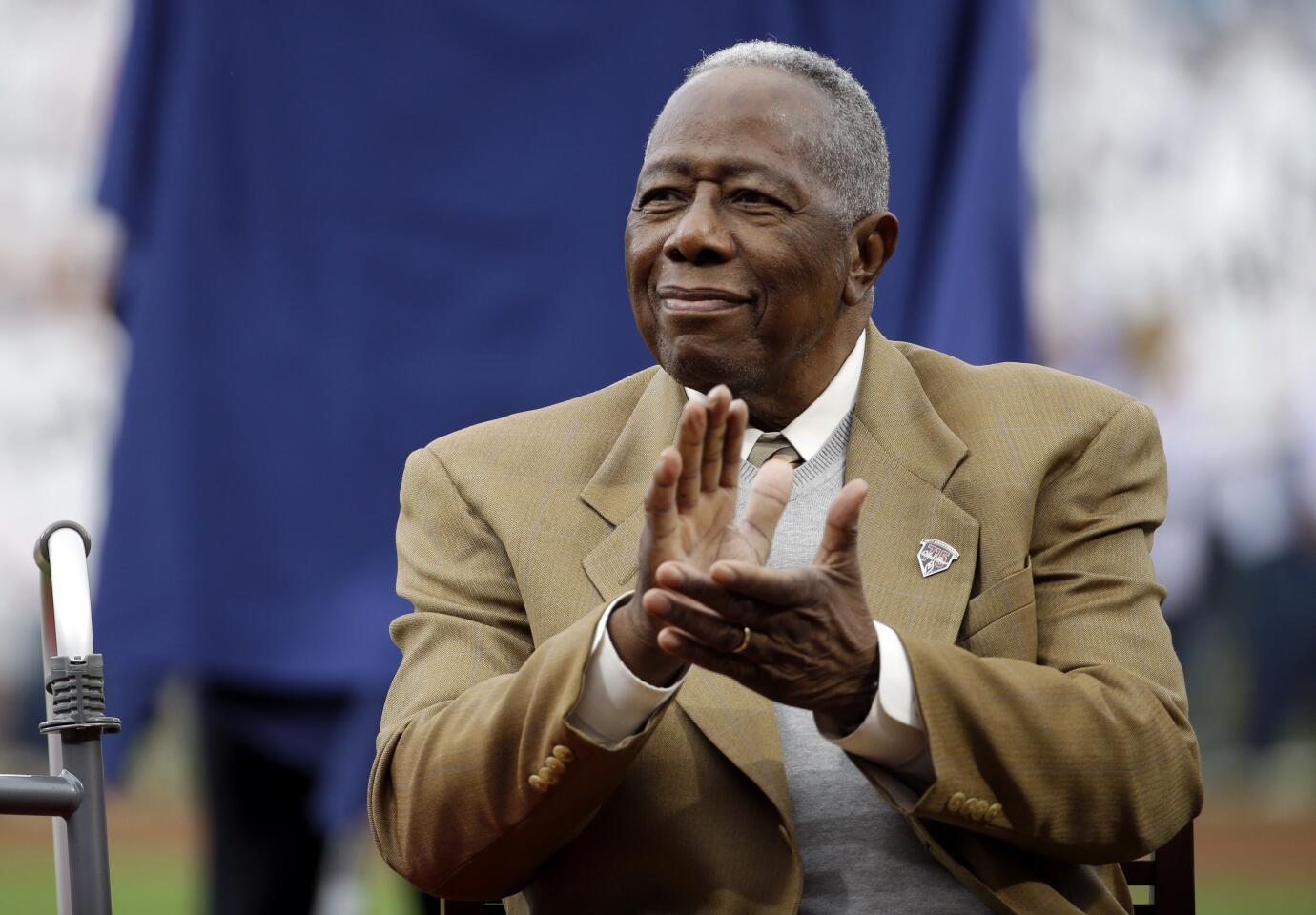 Hank Aaron applauds during a ceremony celebrating the 40th anniversary of his 715th home run