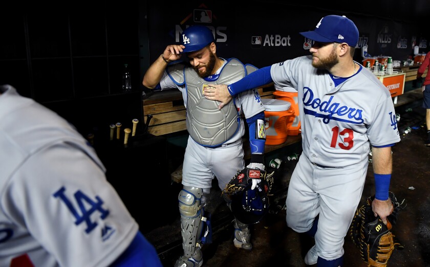 Dodgers catcher Russell Martin, left, gets a pat on the chest from Max Muncy after the Dodgers' win over the Nationals in Game 3 of the NLDS on Sunday.