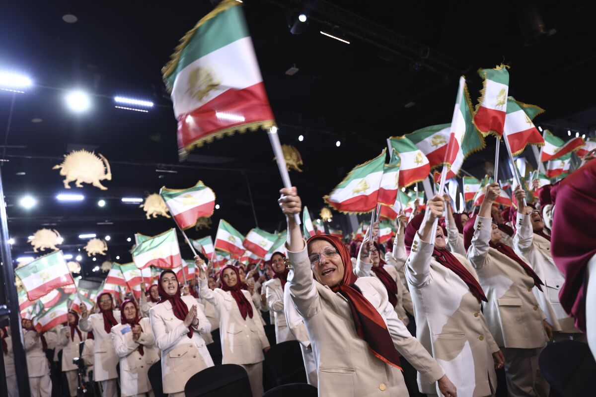 Members of the Ashraf-3 camp wave Iranian flags during the speech of former U.S. Vice President Mike Pence at the Iranian opposition headquarters in Albania, where up to 3,000 MEK members reside at Ashraf-3 camp in Manza town, about 30 kilometers (16 miles) west of Tirana, Albania, Thursday, June 23, 2022. (AP Photo/Franc Zhurda)