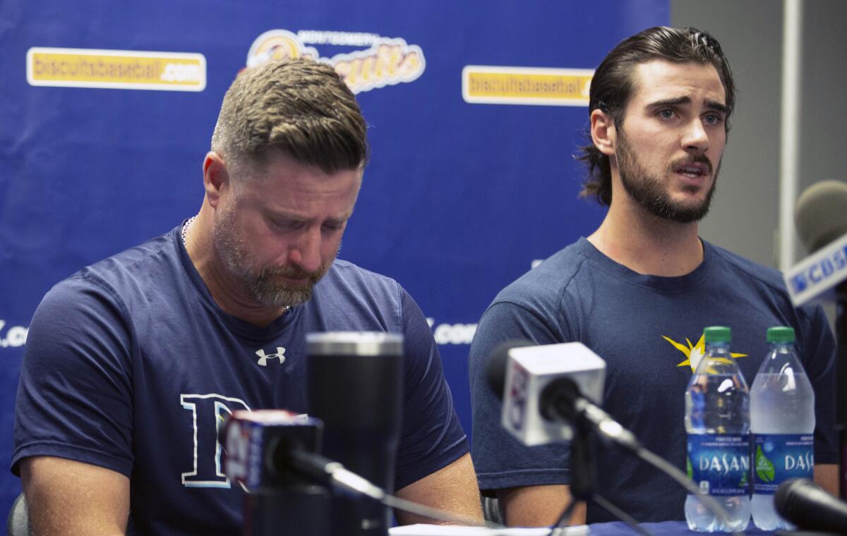 Montgomery Biscuits manager Morgan Ensberg, left, fights back tears as Ryan Thompson, a pitcher with the team, talks about teammate Blake Bivens during a news conference on Thursday.