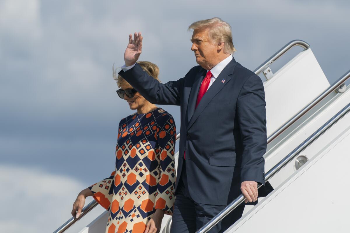 Donald Trump, with Melania Trump, waving from Air Force One steps