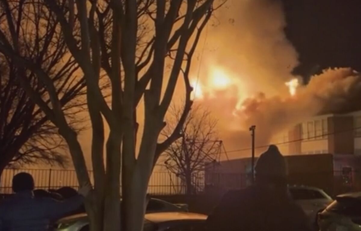 In this grab taken from video provided by Lauren Serpa, bystanders watch as fire and smoke rise from the William Fox Elementary School, in Richmond, Virginia, Friday, Feb. 11, 2022. The Richmond Fire Investigations Unit are working to determine the cause and origin of a fire that engulfed William Fox Elementary School in Richmond. The Richmond Fire Department said in a post on Twitter that crews responded to a report of a building fire Friday at about 10:35 p.m. No injuries have been reported. (Lauren Serpa via AP)