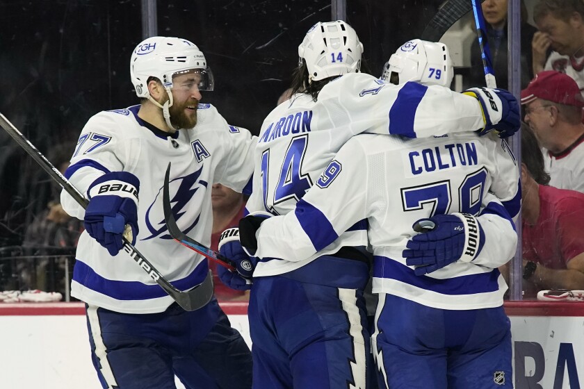 Tampa Bay Lightning defenseman Victor Hedman (77) and left wing Pat Maroon (14) congratulate center Ross Colton (79) following Colton's goal against the Carolina Hurricanes during the third period in Game 5 of an NHL hockey Stanley Cup second-round playoff series in Raleigh, N.C., Tuesday, June 8, 2021. (AP Photo/Gerry Broome)
