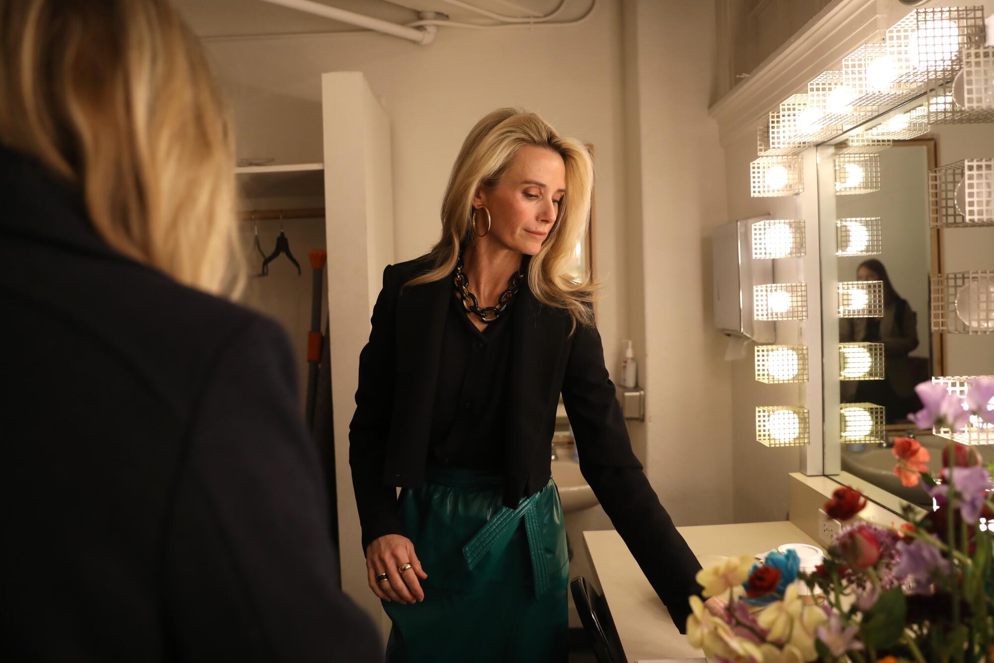  Jennifer Siebel Newsom standing near a lighted mirror in a dressing room.
