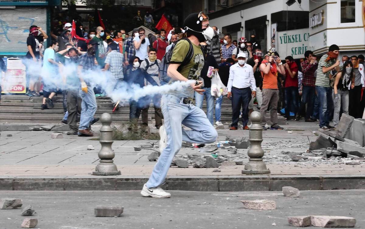 A protester throws a tear-gas canister back at police as he takes part in a demonstration against the ruling Justice and Development Party in Ankara, Turkey's capital.