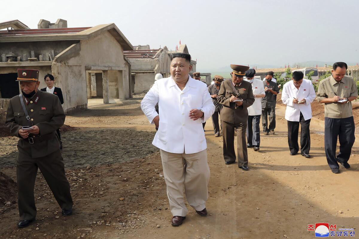 el gobernante Kim Jon Un, al centro, visita una granja avícola en construcción en el distrito de Hwangju, 