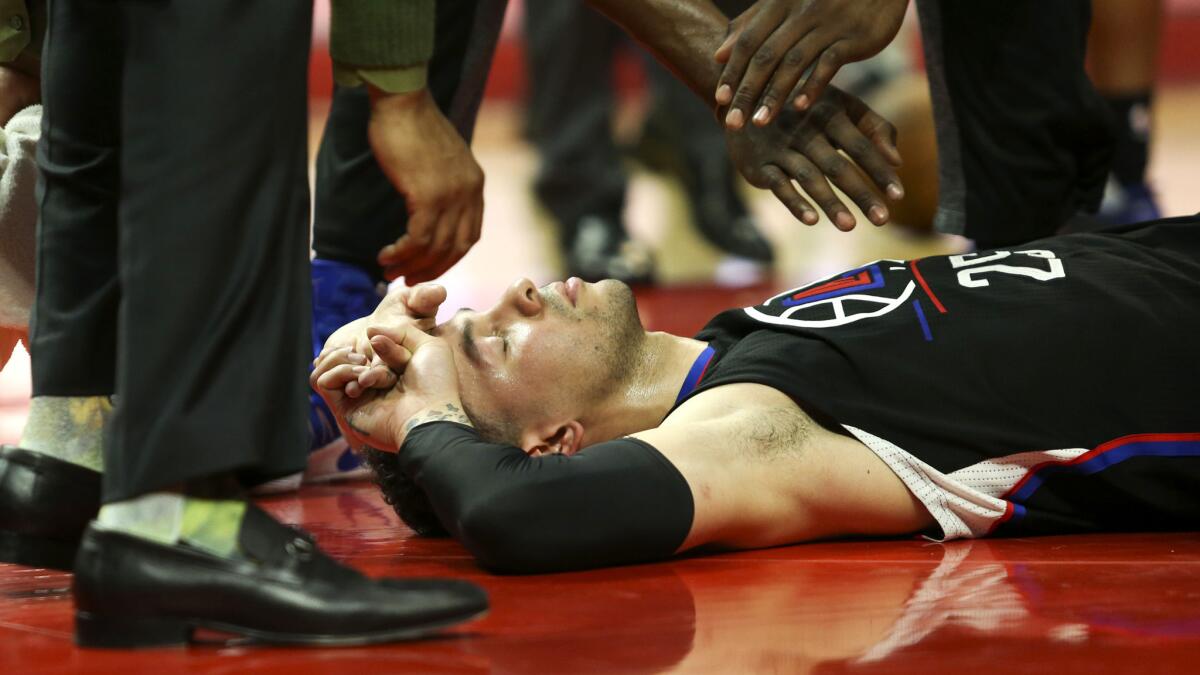 Guard Austin Rivers is checked on by Clippers personnel after falling to the court following an inadvertent blow to the chin during the game against New Orleans on Saturday night.