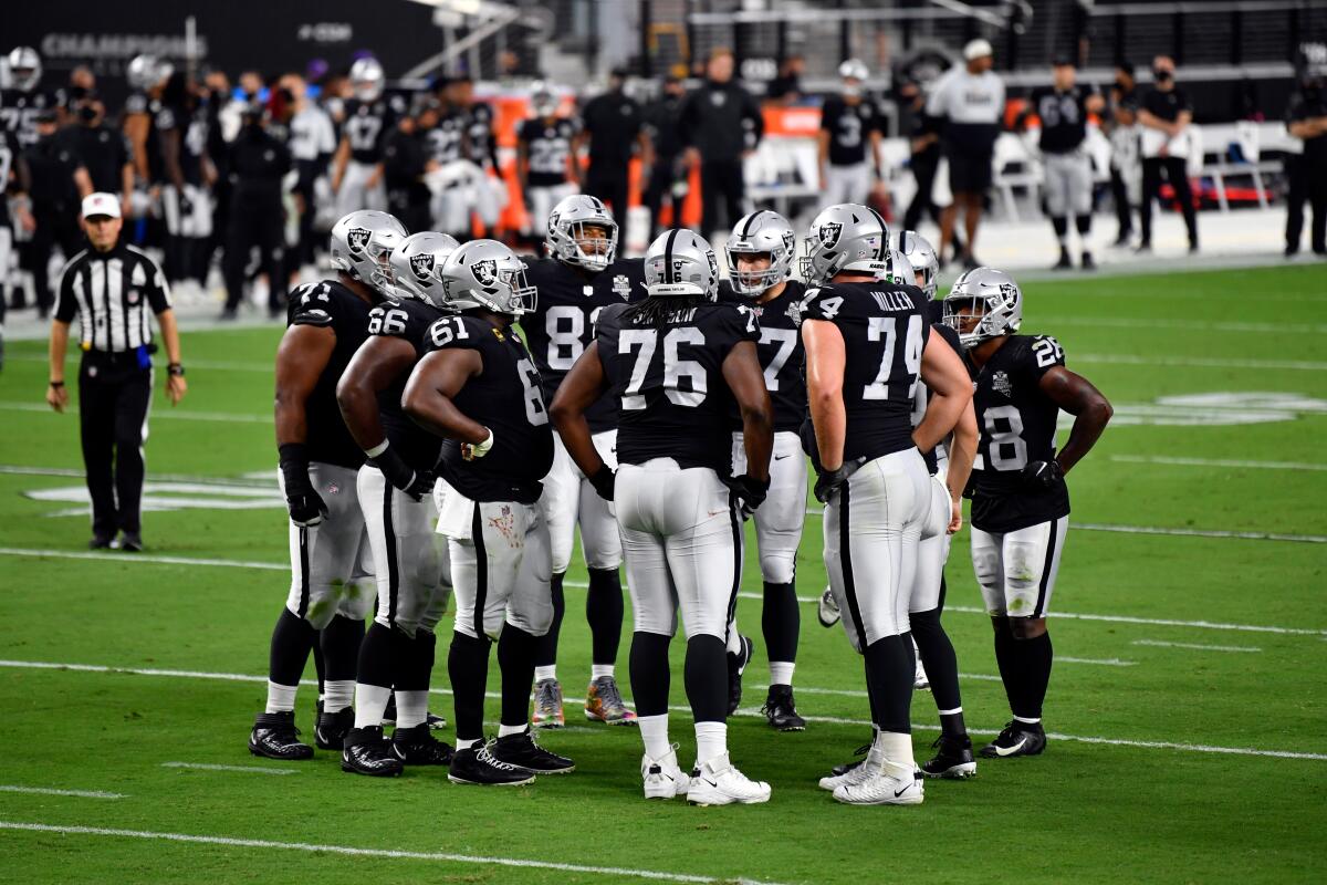 The Las Vegas Raiders huddle between plays against the New Orleans Saints.