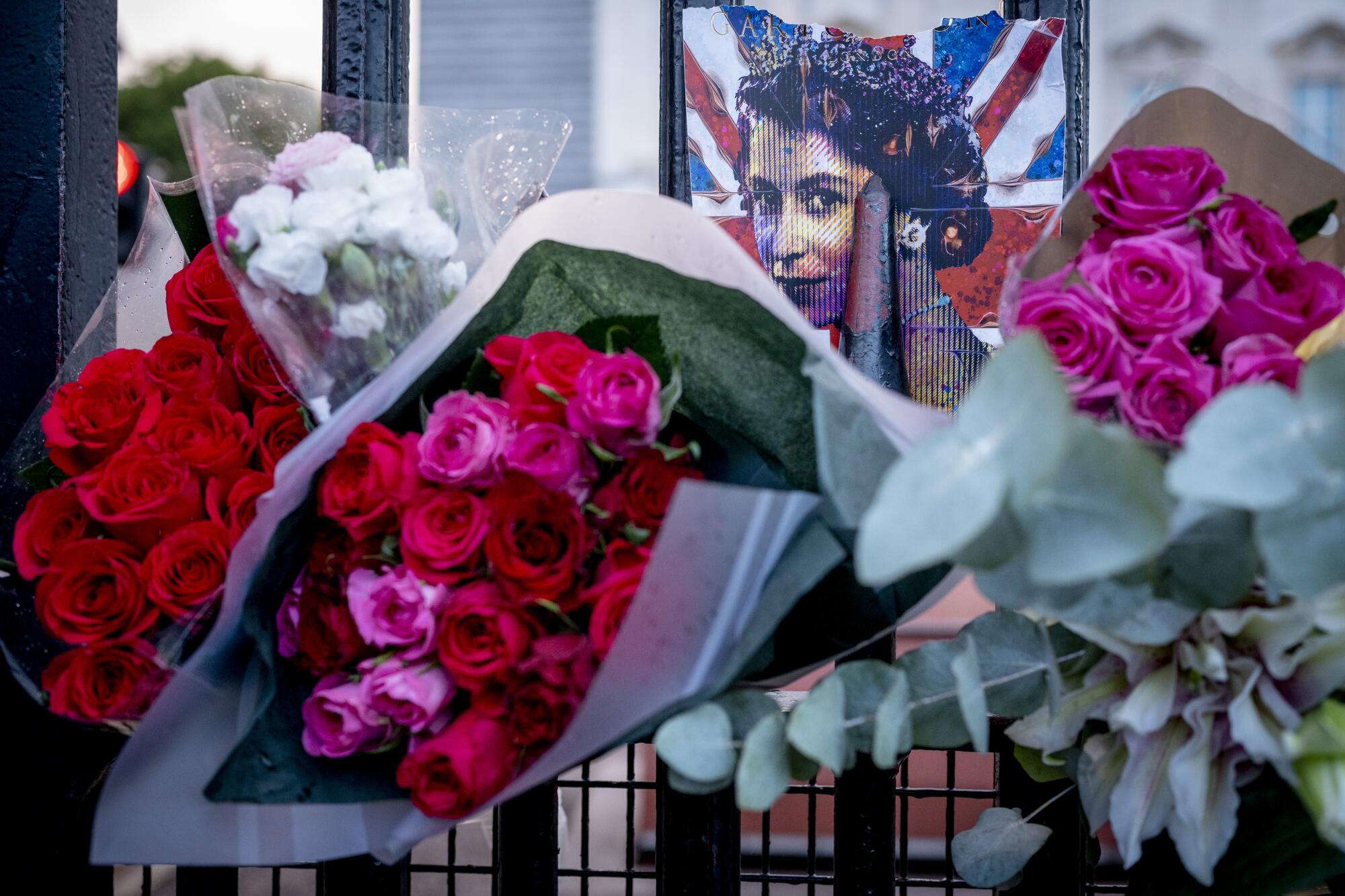 Bouquets of flowers are attached to the gates of Buckingham Palace in London.