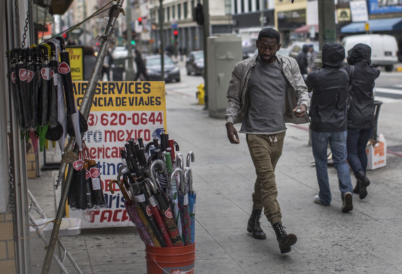 A man eyes an umbrella stand as April showers fall in dowtown Los Angeles Saturday.