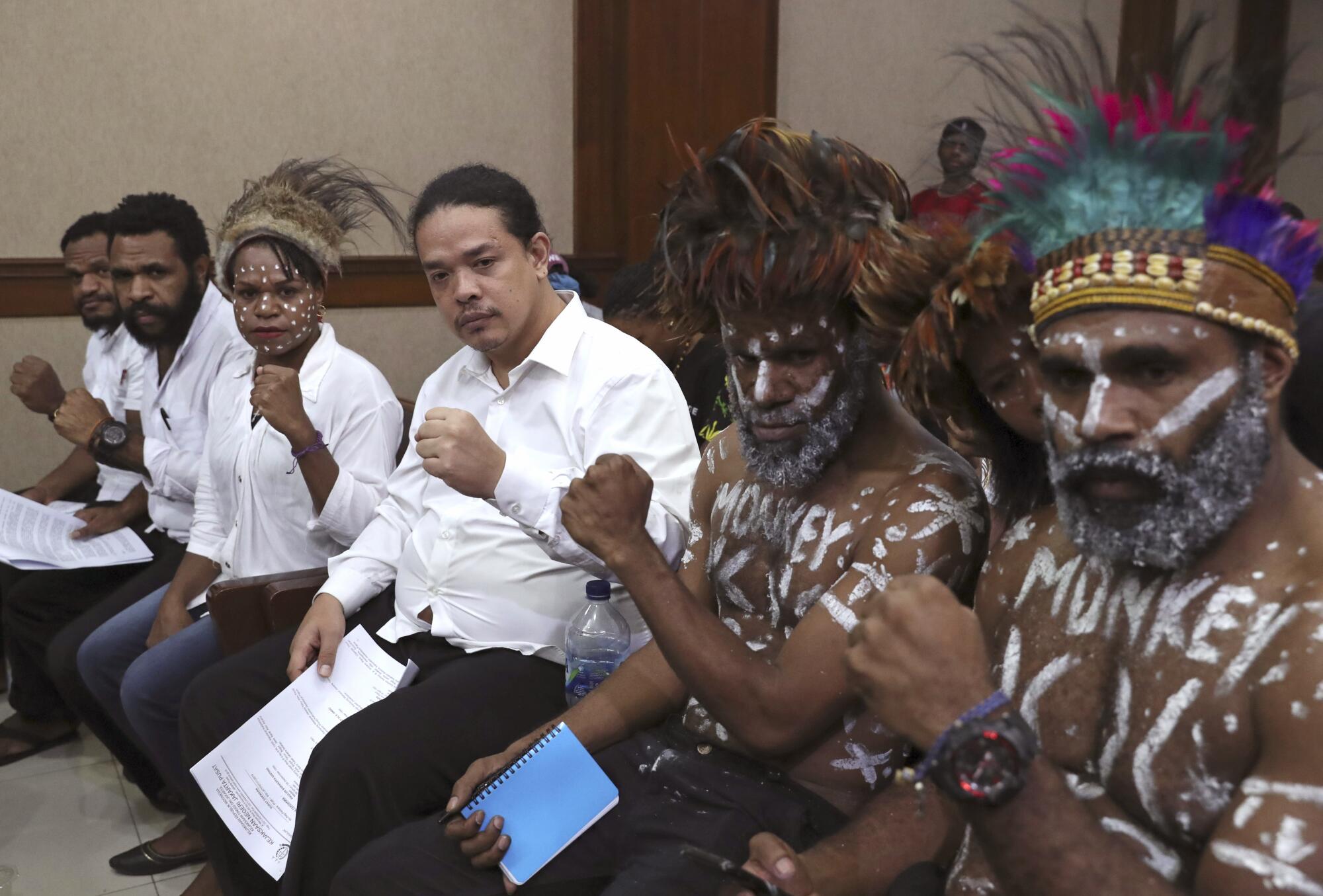 Papuan independence activists pose for photographers before the start of their trial 