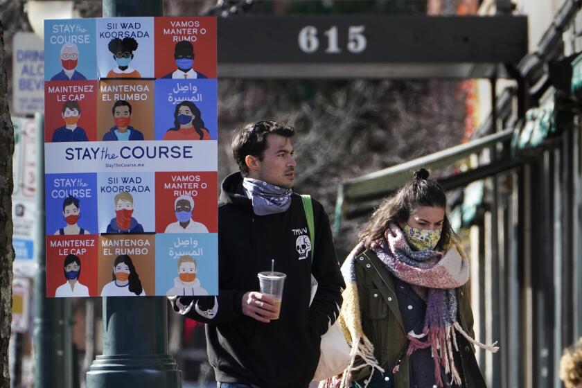 Un cartel en varios idiomas insta a los ciudadanos a cubrirse el rostro para frenar los contagios de COVID-19 en Portland, Maine. (AP Foto/Robert F. Bukaty)