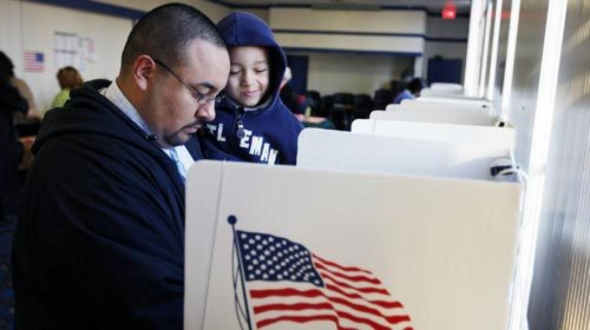 Abraham C. Gomez Jr., 4, watches his father, Abraham Gomez, cast his early-morning ballot during the California primary on Super Tuesday at AMF Beverly Lanes in Montebello.