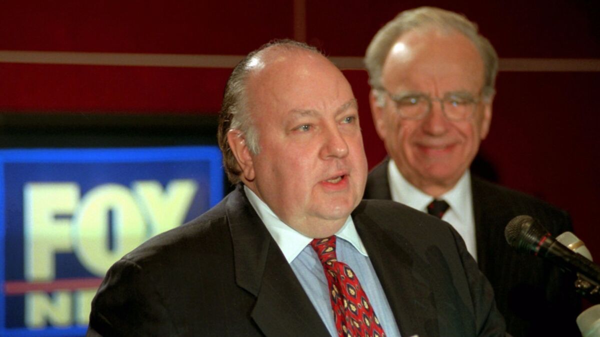 Roger Ailes, left, speaks at a news conference on Jan. 30, 1996, as Rupert Murdoch looks on after it was announced that Ailes will be chairman and CEO of Fox News.