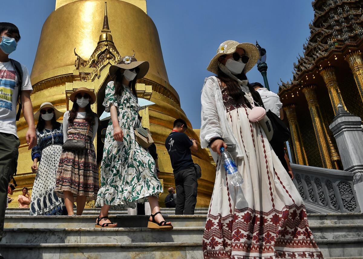 Tourists wearing face masks visit the Grand Palace in Bangkok on Jan. 29, 2020.