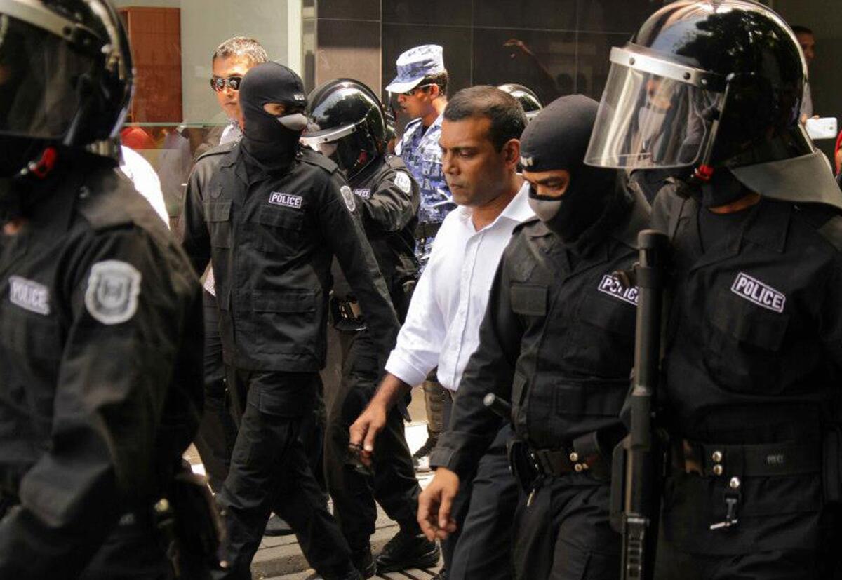 Former Maldivian President Mohamed Nasheed, center, is surrounded by police after his arrest in Male, capital of the Maldives.