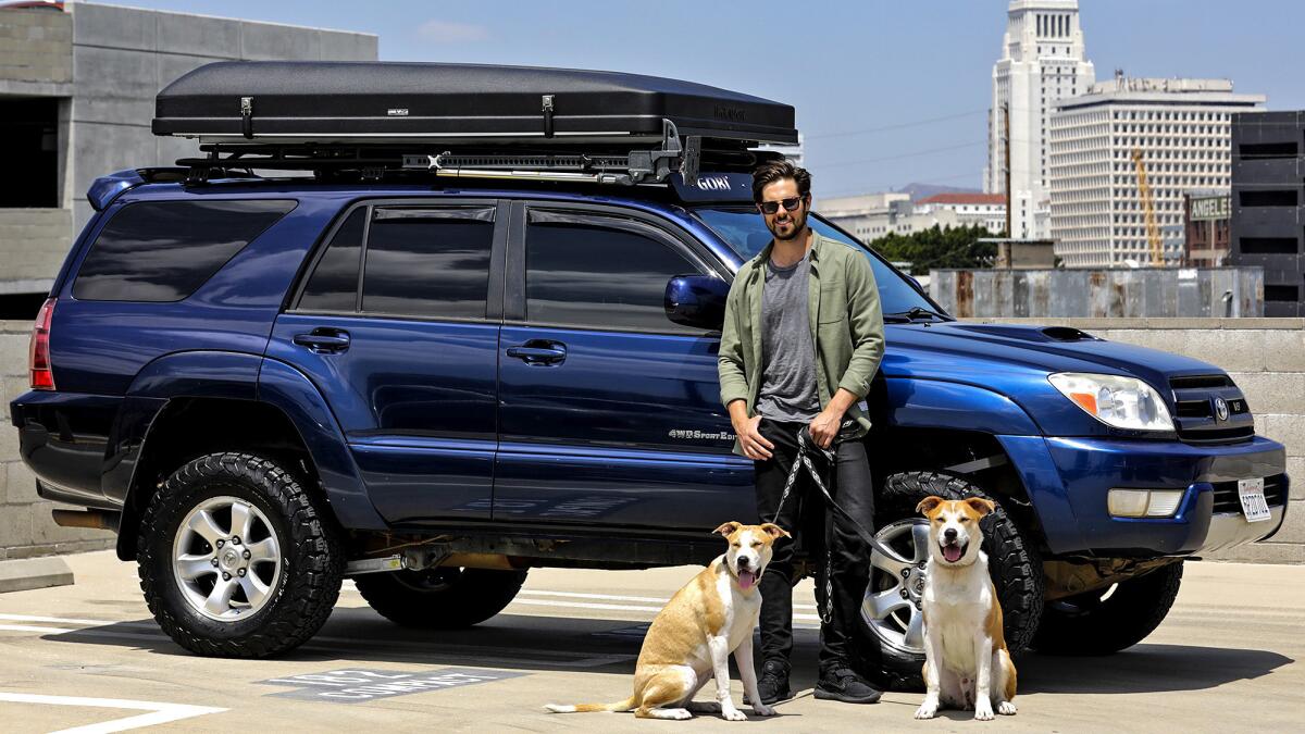 Actor Chris McNally in his rooftop camper installed on 2005 Toyota 4Runner Sports Edition 4WD V8 with his two dogs Bowie and Charley.