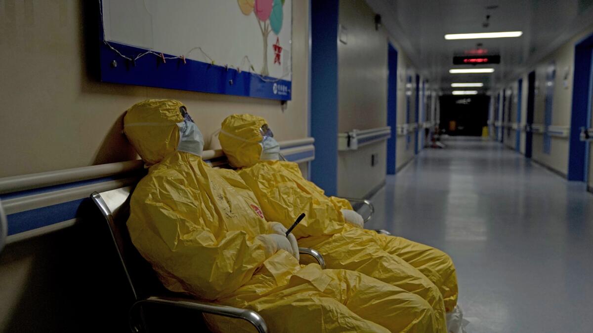Trabajadores del hospital agotados, vestidos con Equipo de Protección Personal en el documental “76 Días”.