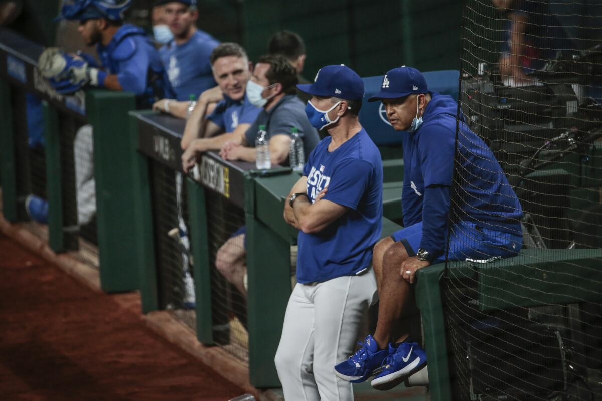 Dodgers bench coach Bob Geren and manager Dave Roberts watch batting practice at Globe Life Field.
