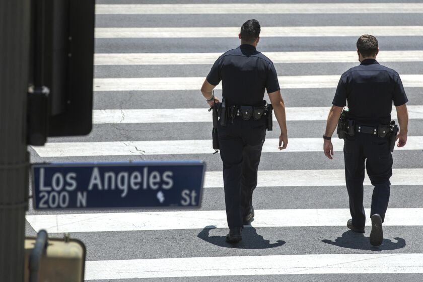 LOS ANGELES, CA - JUNE 21, 2021: Members of the LAPD make their way along Temple St. in downtown Los Angeles. (Mel Melcon / Los Angeles Times)