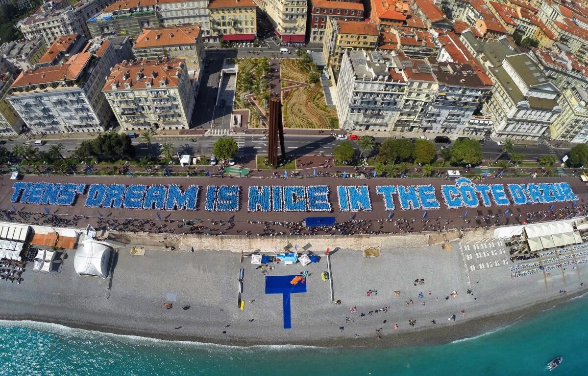 An aerial picture released by Image Trans on May 8 shows employees of Chinese company Tiens arranging themselves on the Promenade des Anglais in the French city of Nice to spell out the phrase "Tiens' dream is Nice in the Cote d'Azur."