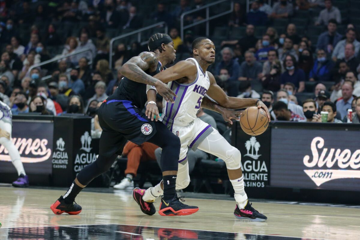 Sacramento Kings guard De'Aaron Fox drives against Clippers guard Eric Bledsoe.