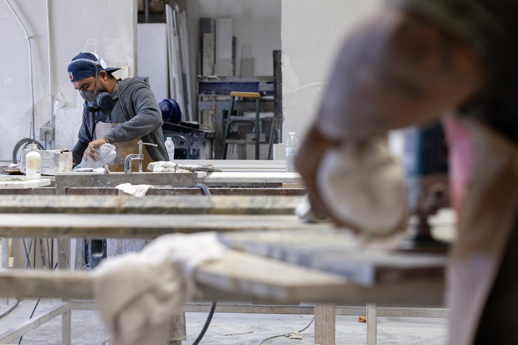 Countertop fabricators cut stone in a workshop in Sun Valley.