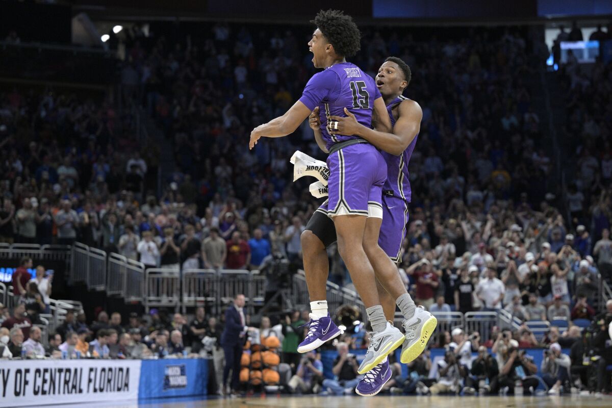 Furman forwards Tyrese Hughey and Alex Williams celebrate their win against Virginia.