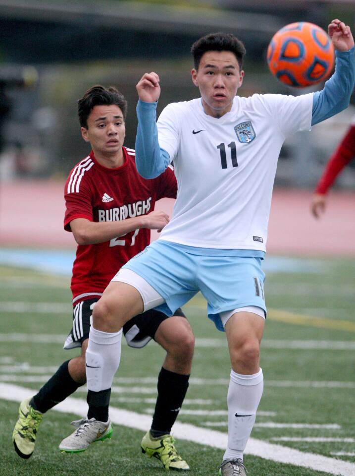 Crescenta Valley High School boys soccer player #11 Jonathan Han gets a throw-in with #27 Ari Rango tightly covering him during game at home vs. Burroughs High School at home in La Crescenta on Tuesday, Feb. 7, 2017.