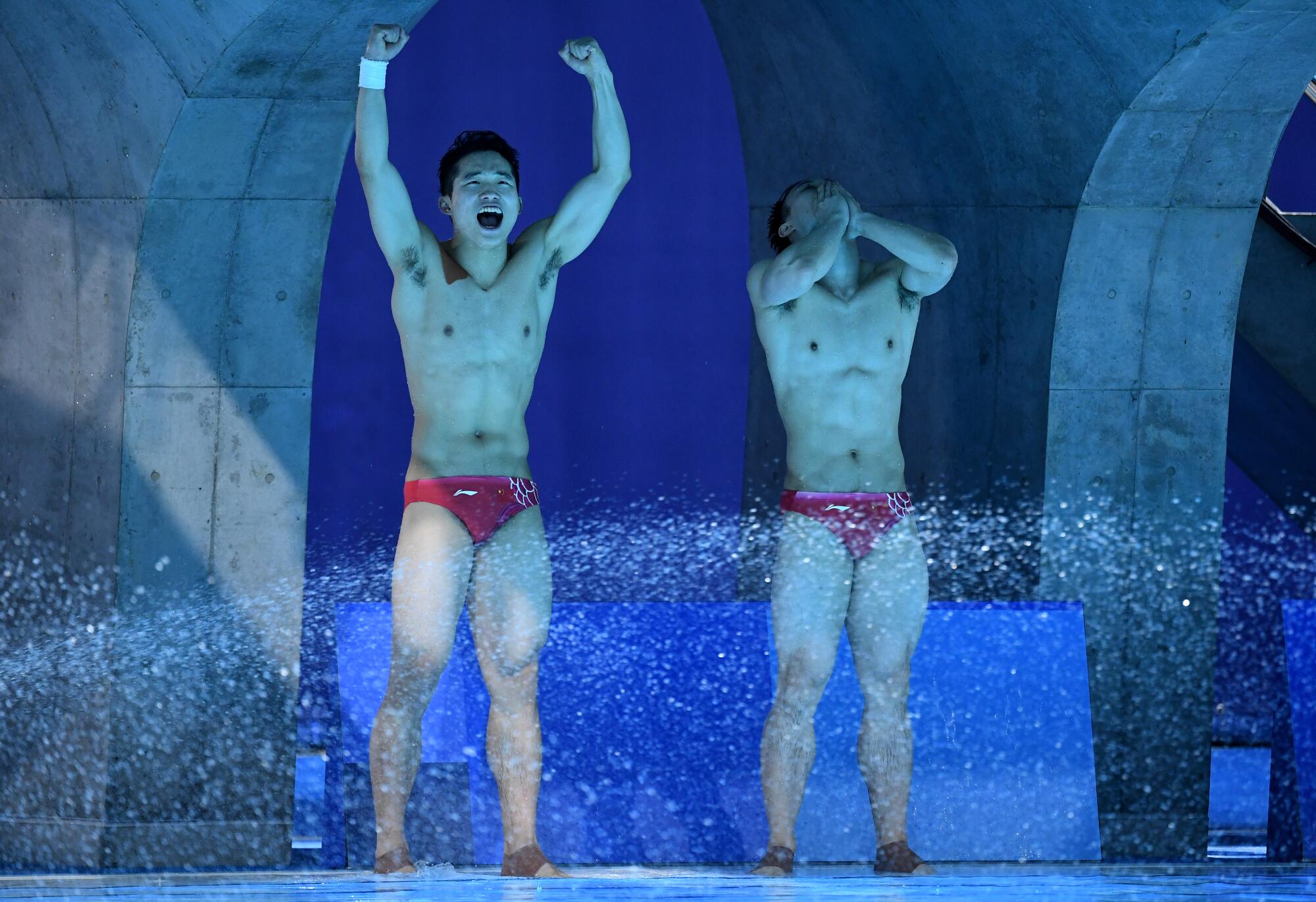 Two Chinese divers celebrate at poolside 