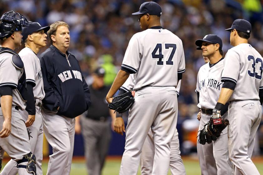 Yankees starting pitcher Ivan Nova (47) is visited on the mound Saturday after injuring his elbow.