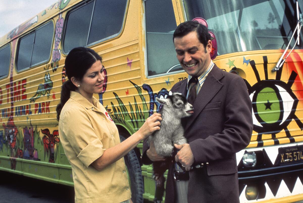 Children's Zoo attendant Mary Lieras and a pygmy goat pose with the zoo's Executive Director Chuck Bieler in 1979.
