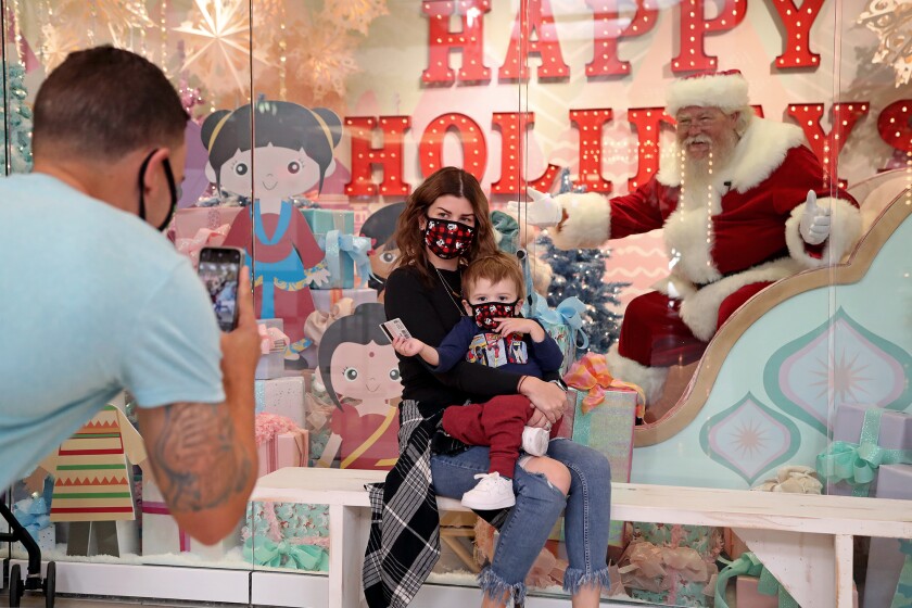 Jay Olavarria, left, of Westminster takes a photo of his wife and son at South Coast Plaza.