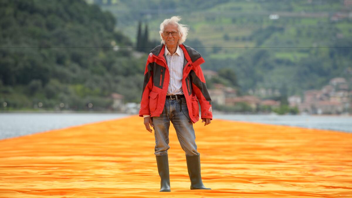 The artist Christo walks on his monumental installation "The Floating Piers" in Italy. 