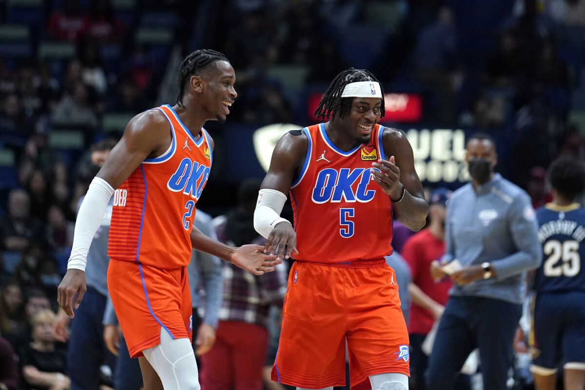 Oklahoma City Thunder guard Shai Gilgeous-Alexander (2) and forward Luguentz Dort (5) laugh as they walk off court, after Gilgeous-Alexander's 3-pointer in the second half of an NBA basketball game against the New Orleans Pelicans in New Orleans, Wednesday, Nov. 10, 2021. The Thunder won 108-100.(AP Photo/Gerald Herbert)