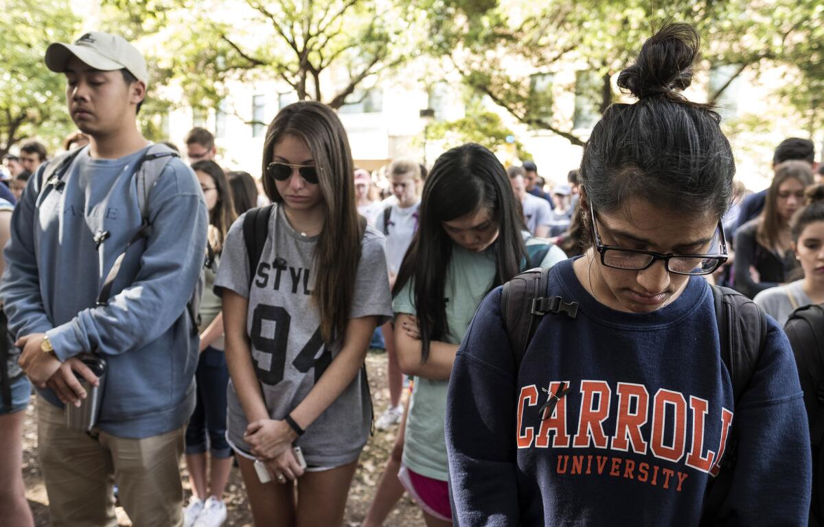 Mourners observe a moment of silence during a vigil for University of Texas at Austin student Haruka Weiser on the campus Thursday.