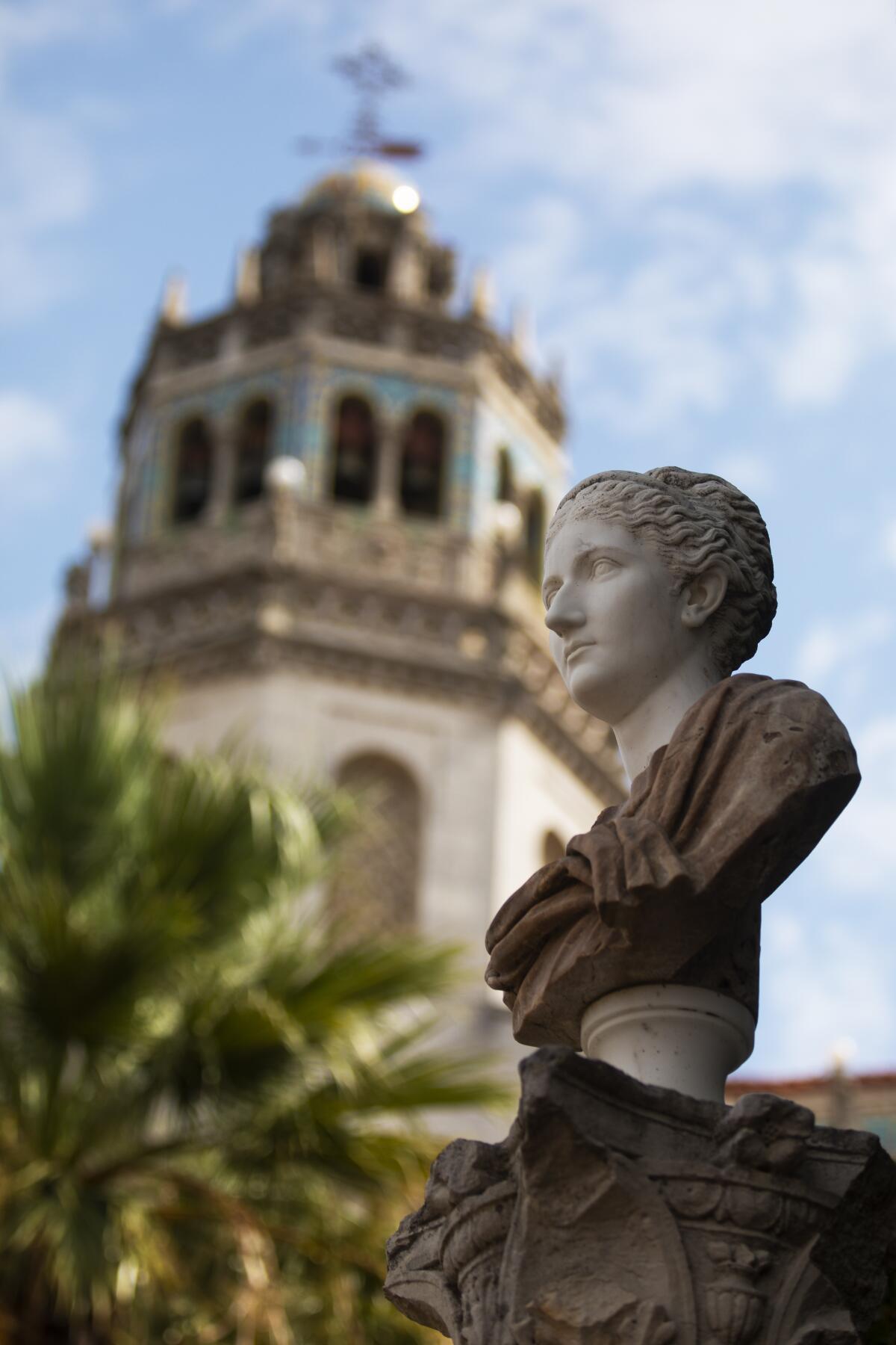 A marble bust made in the style of Ancient Rome depicts a young Roman senator in front of Casa Grande at Hearst Castle.