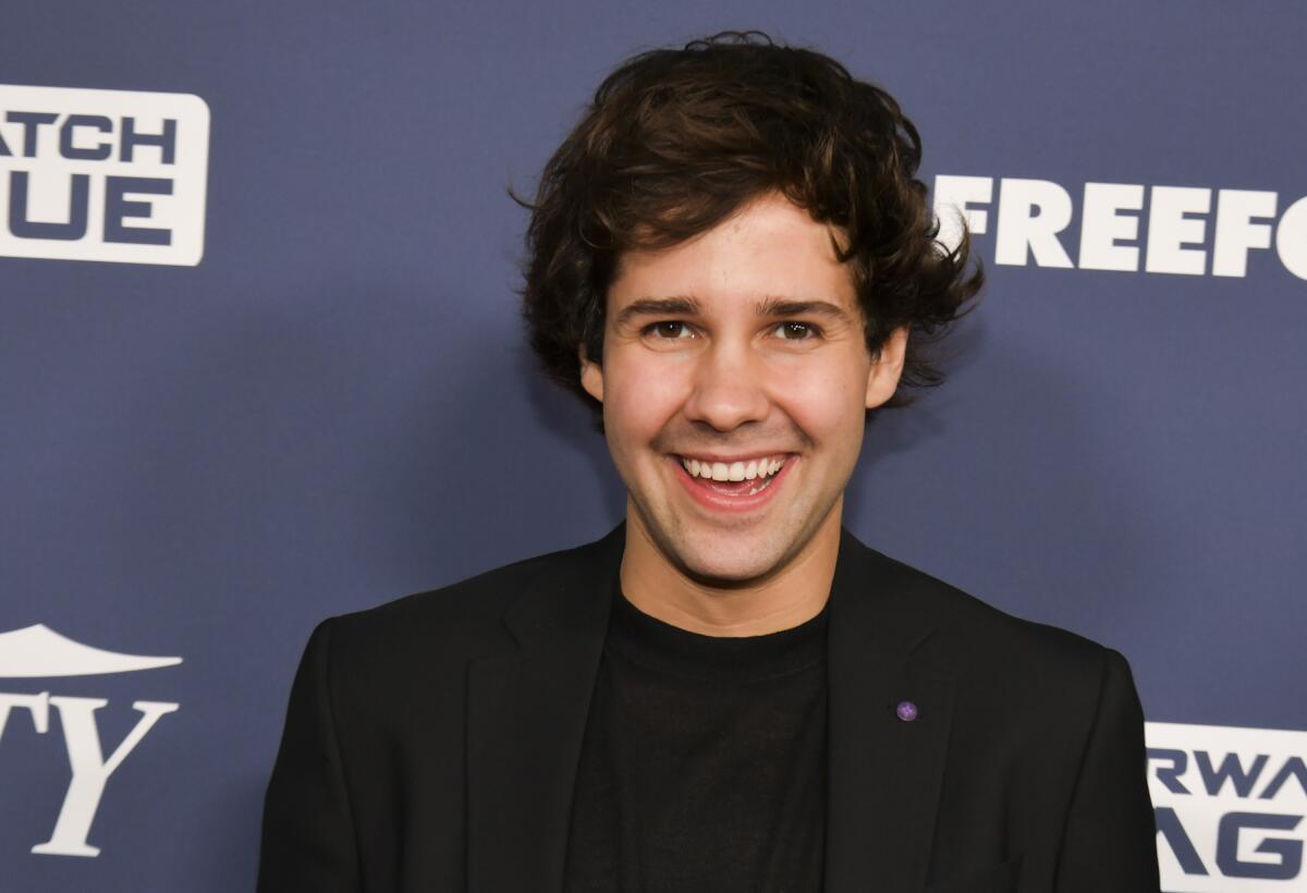 David Dobrik smiling in a black suit