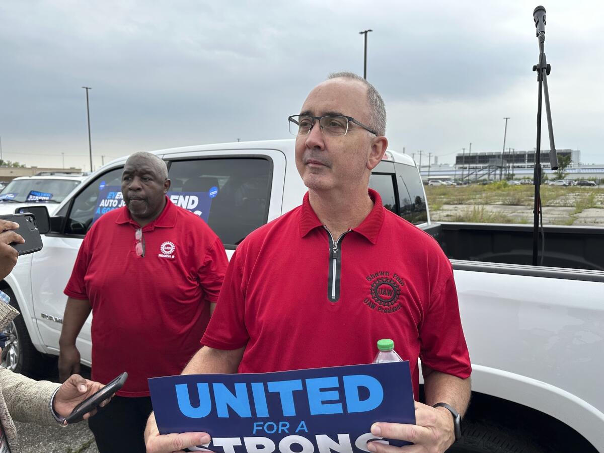 United Auto Workers President Shawn Fain holds up a sign