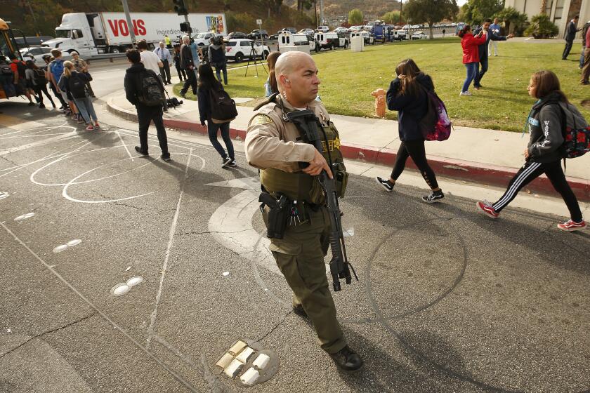 SAUGUS, CA - NOVEMBER 14, 2019 Police officers escort students as they board buses from Saugus High School to a nearby park to be reunited with their parents after at least six people were wounded in a shooting at Saugus High School when a gunman opened fire on the Santa Clarita campus early Thursday. (Al Seib / Los Angeles Times)