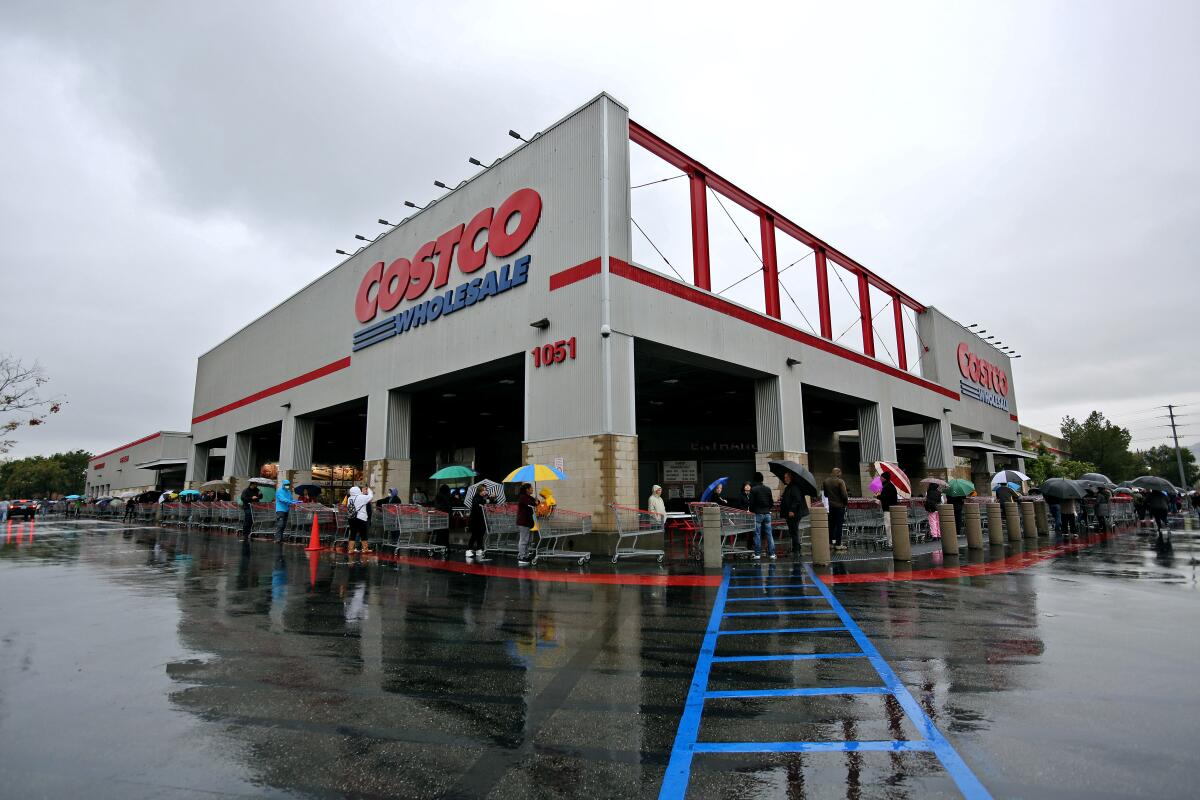 Customers line up around a building with the word "Costco" on it.