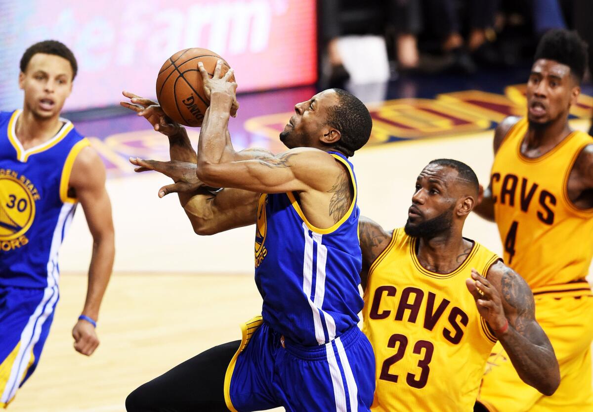 Warriors forward Andre Iguodala is fouled by Cavaliers forward LeBron James on a layup in the second half of Game 4 on Thursday night in Cleveland.