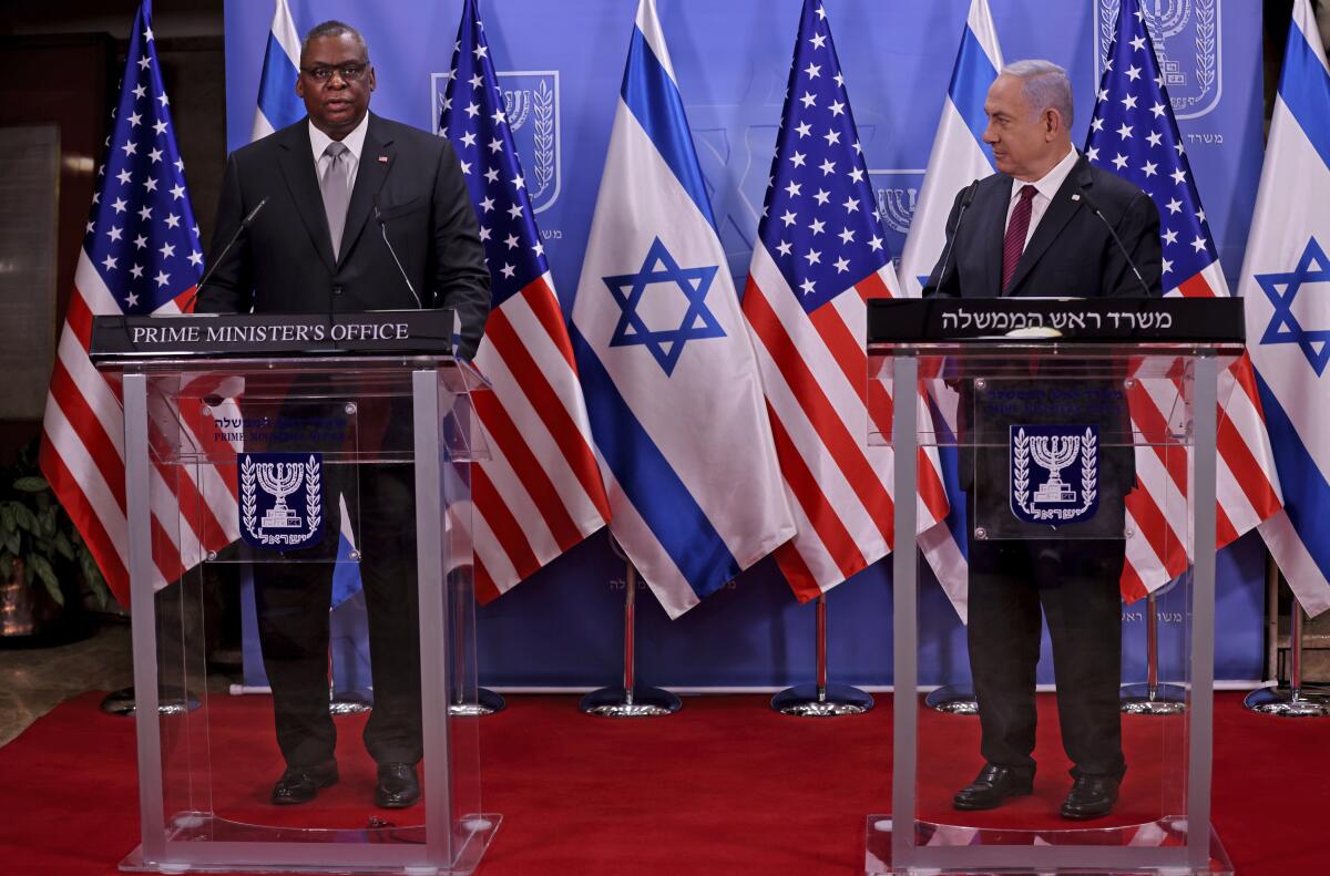 U.S. Defense Secretary Lloyd J. Austin III and Israeli Prime Minister Benjamin Netanyahu stand at lecterns