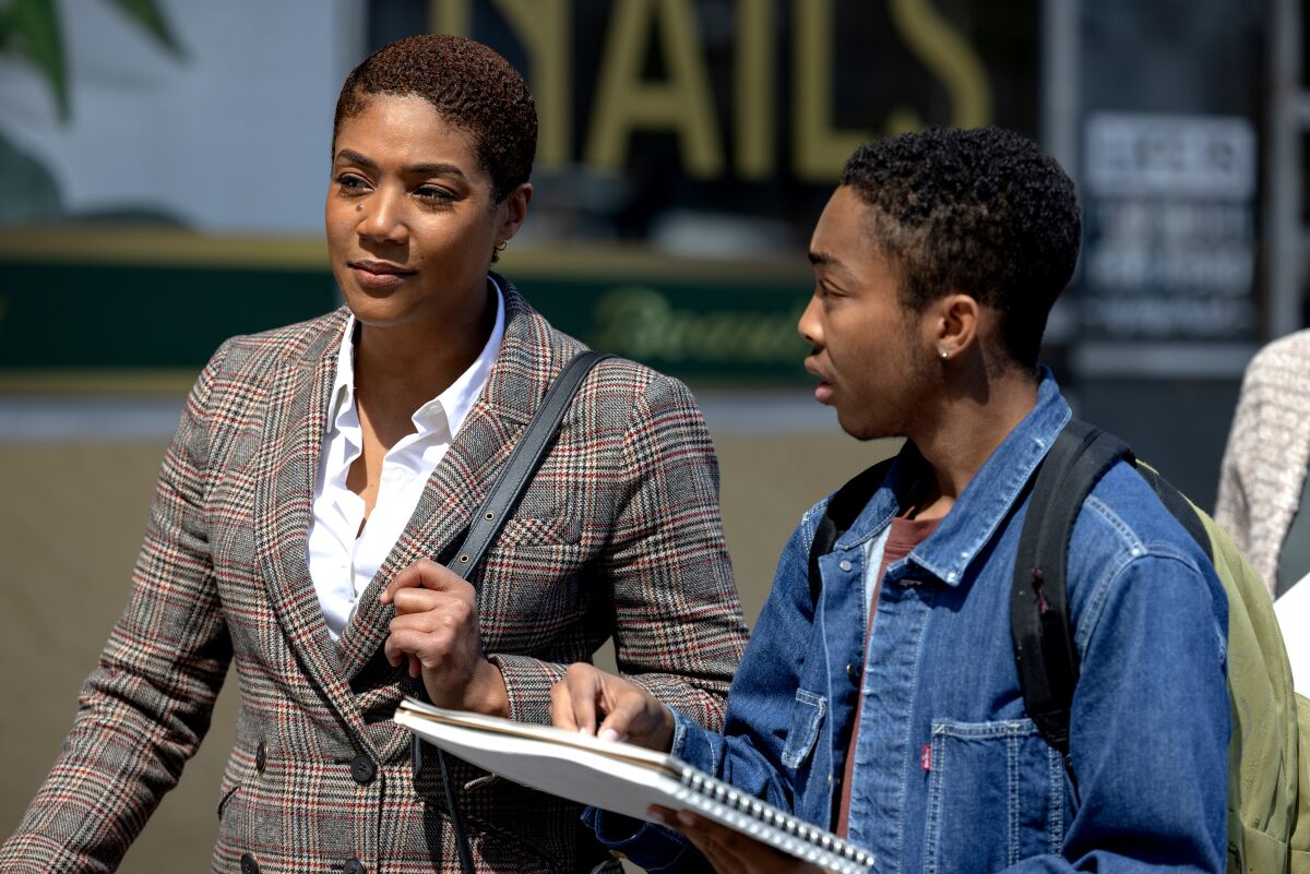 A mother and her son carrying a backpack are having a discussion.