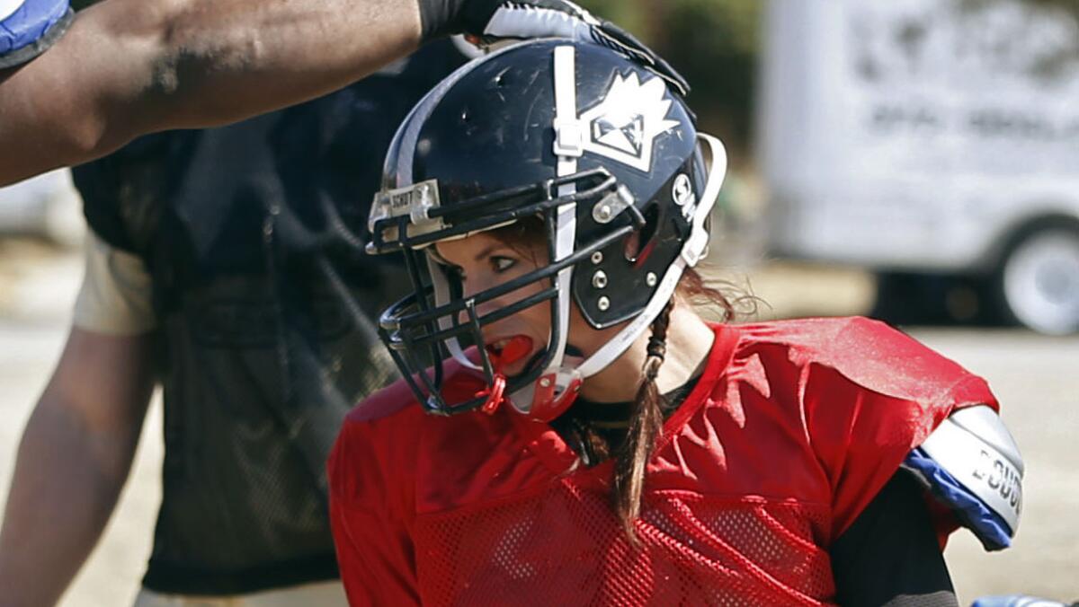 Jen Welter is congratulated by a teammate during a team practice session with the Texas Revolution in February 2014.