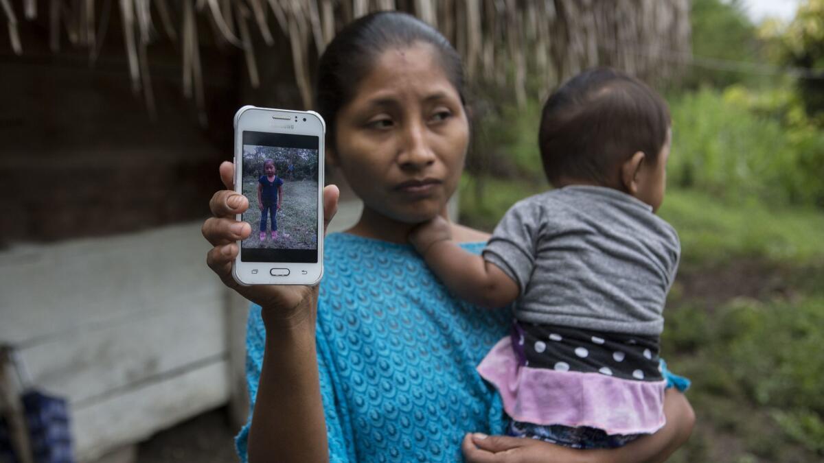Claudia Maquin, 27, in Raxruha, Guatemala, shows a photo Dec. 15 of her daughter Jakelin Caal Maquin. Jakelin, 7, died in a Texas hospital, two days after being taken into custody along with her father.