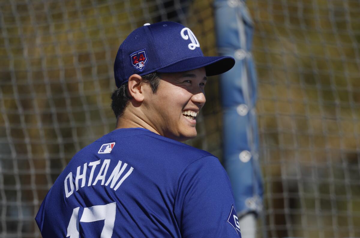 Dodgers star Shohei Ohtani smiles while warming up in the batting cage at spring training on Feb. 14.
